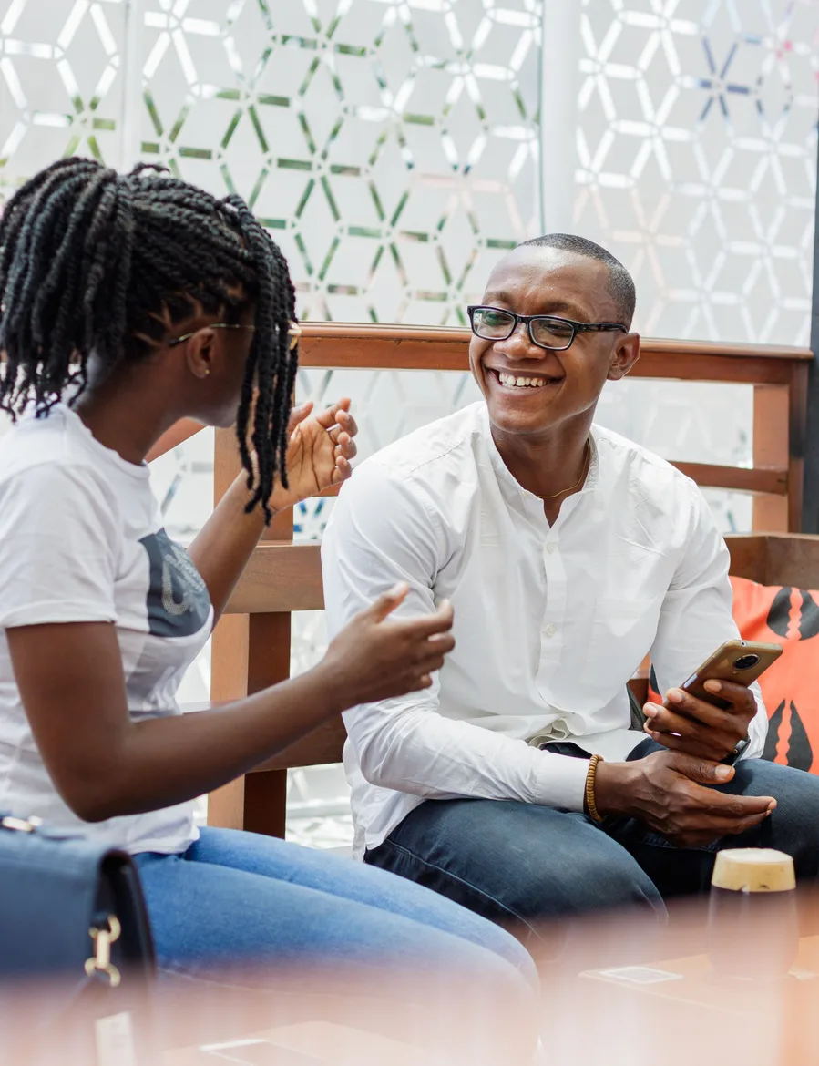Two people enjoying a conversation at an outdoor café in Accra